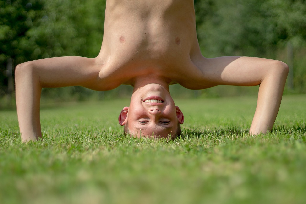 boy game child standing on your head luck summer exercises nature gymnastics childhood carefree holiday joy