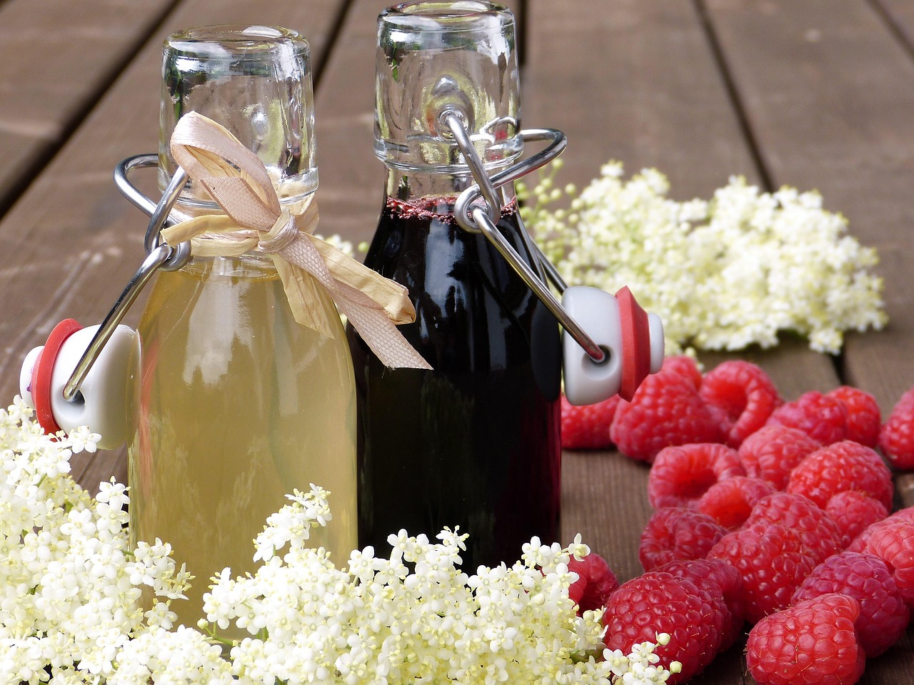 bottles raspberries syrup drink blossoms elderberry syrup raspberry syrup homemade gift invitation summer party outdoors healthy sugar sambucus nigra remedies fresh detox