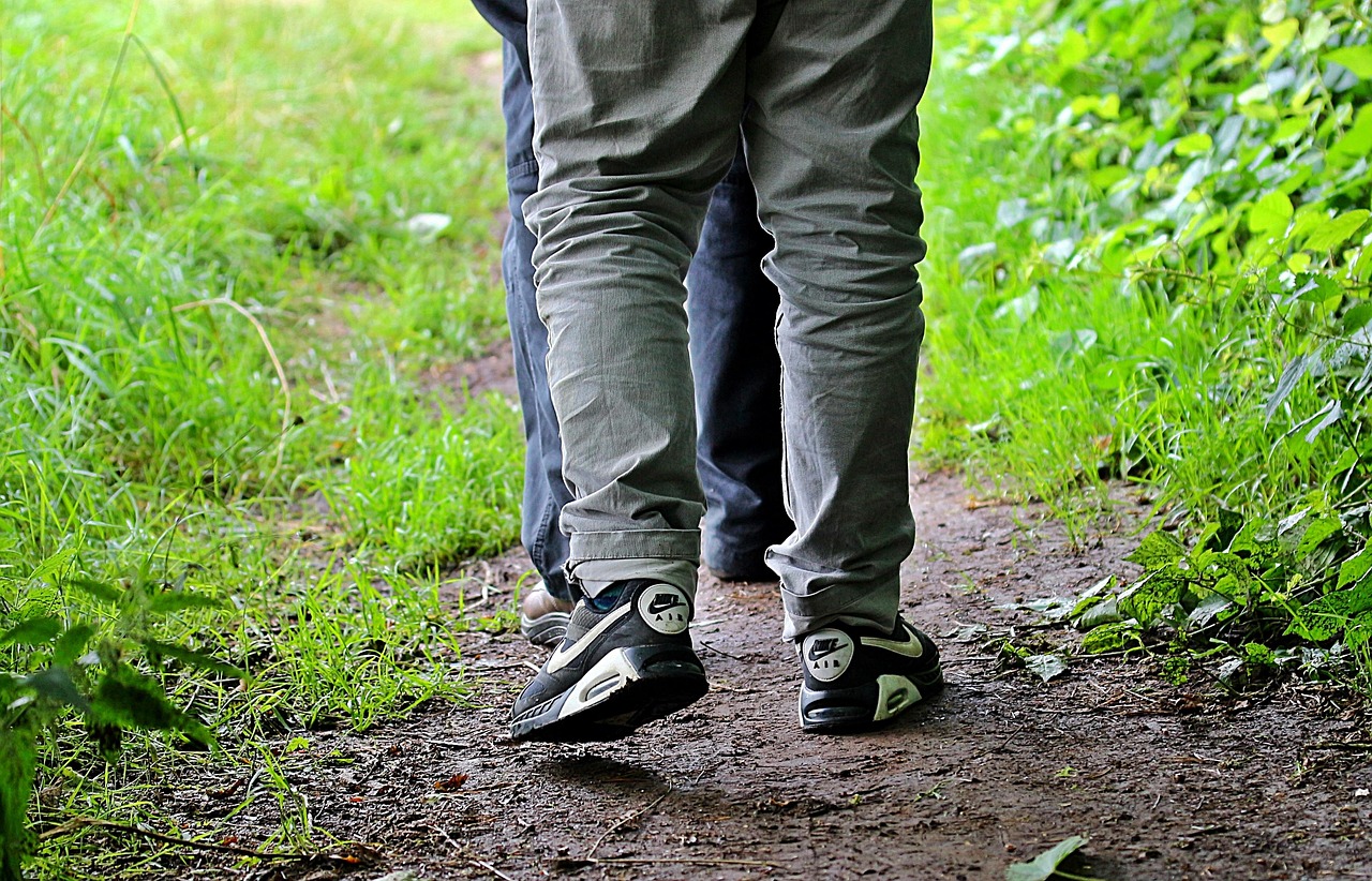 to stroll walk go for a walk path promenade as a couple together hike grass step in step shoes legs on beat move nature outdoors