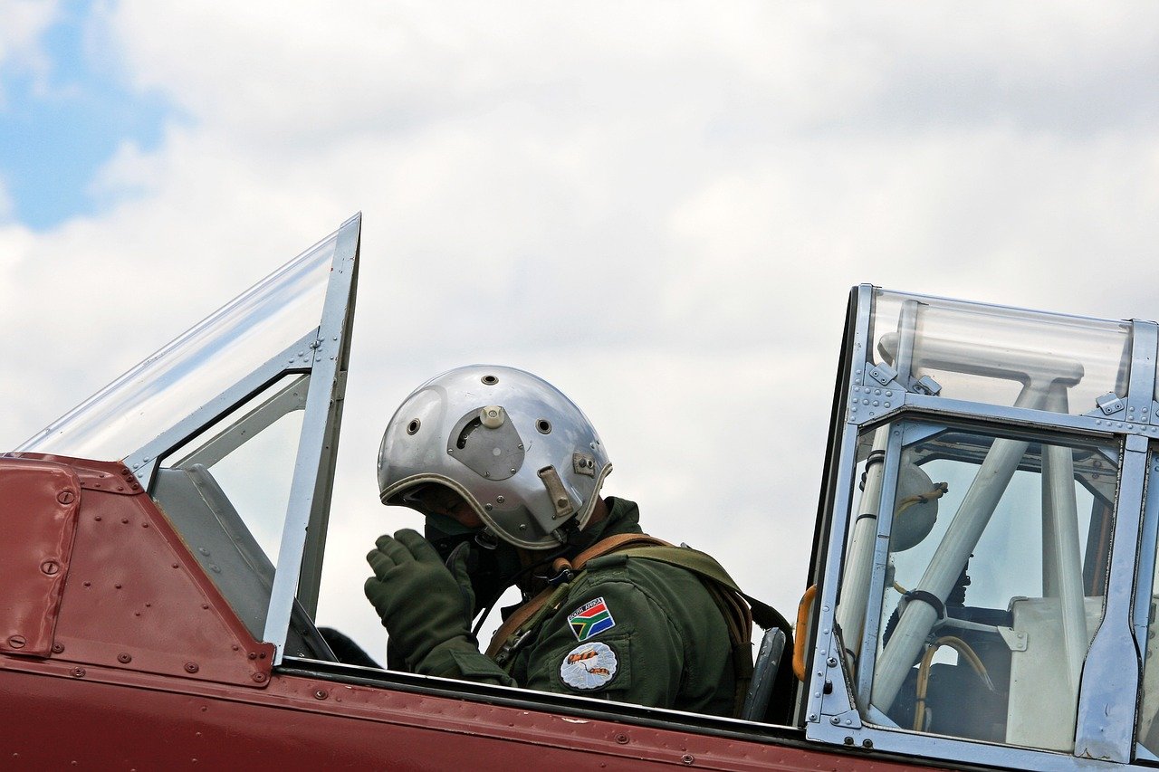 harvard pilot adjusting oxygen mask flying suit cockpit preparing for takeoff south african air force museum aviation