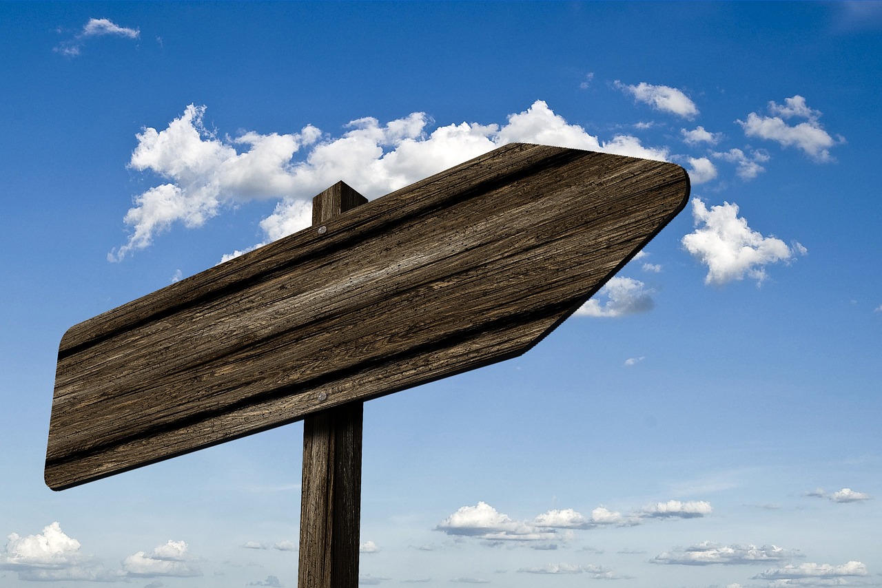 signpost waypoint wood grain board sign direction right nature path marking arrow heaven clouds
