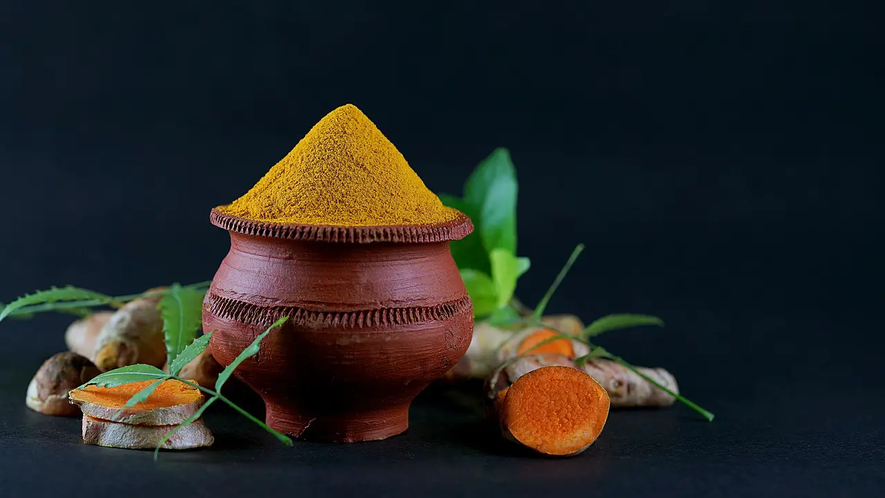 turmeric nature neem cup spoon undried turmeric black background wood spoon full of turmeric leaf dramatic